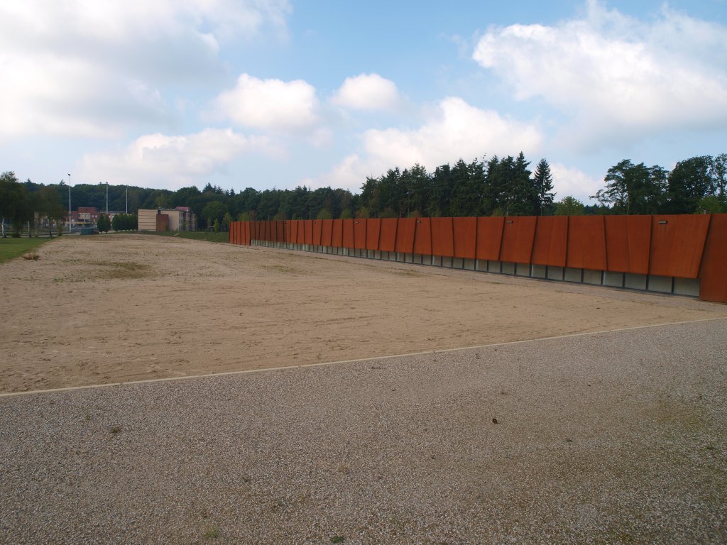 onder de zandplaat liggen de schietbanen; onder de roeststalen wand bevindt zich de sporthal